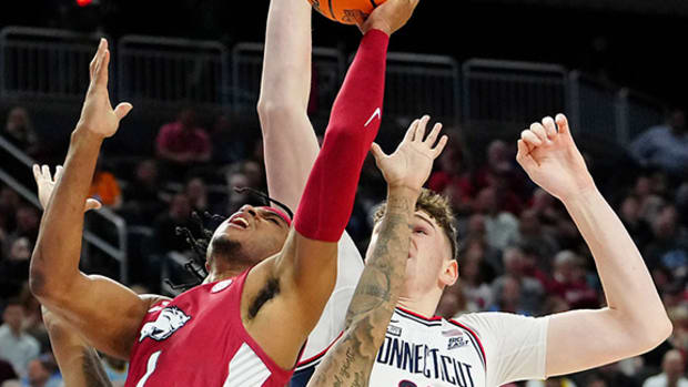 A UConn player blocks the shot of Arkansas guard Ricky Council.